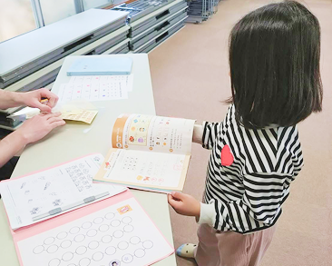 開いたテキストを指差しながら、単語やフレーズを熱心に確認する生徒